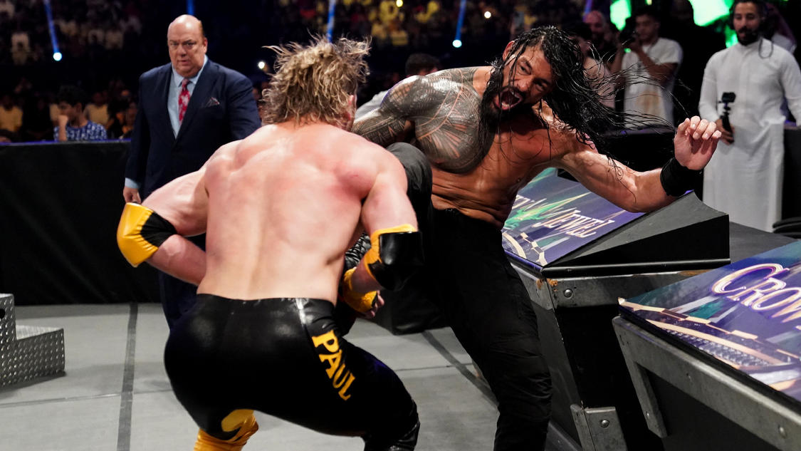 挑戦者ローガン・ポール（手前）と場外乱闘する統一王者ローマン・レインズ（C）2022 WWE, Inc. All Rights Reserve