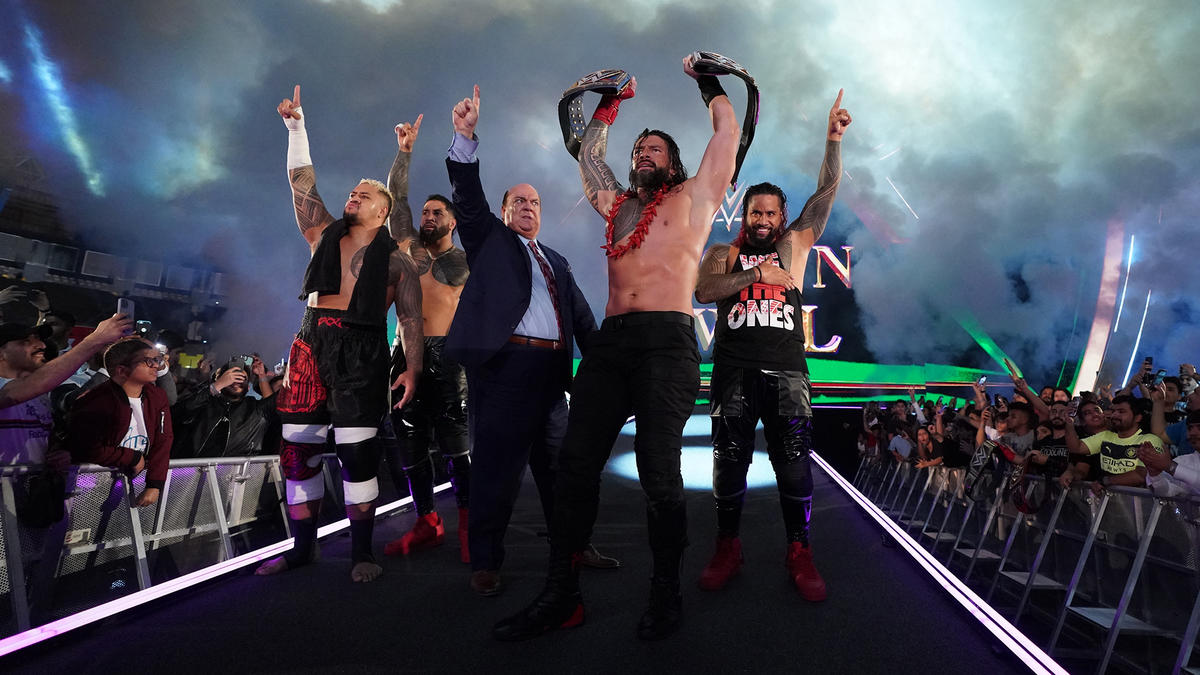 2本の王座ベルトを掲げ、花道を歩く統一王者ローマン・レインズ（左から4番目）（C）2022 WWE, Inc. All Rights Reserve