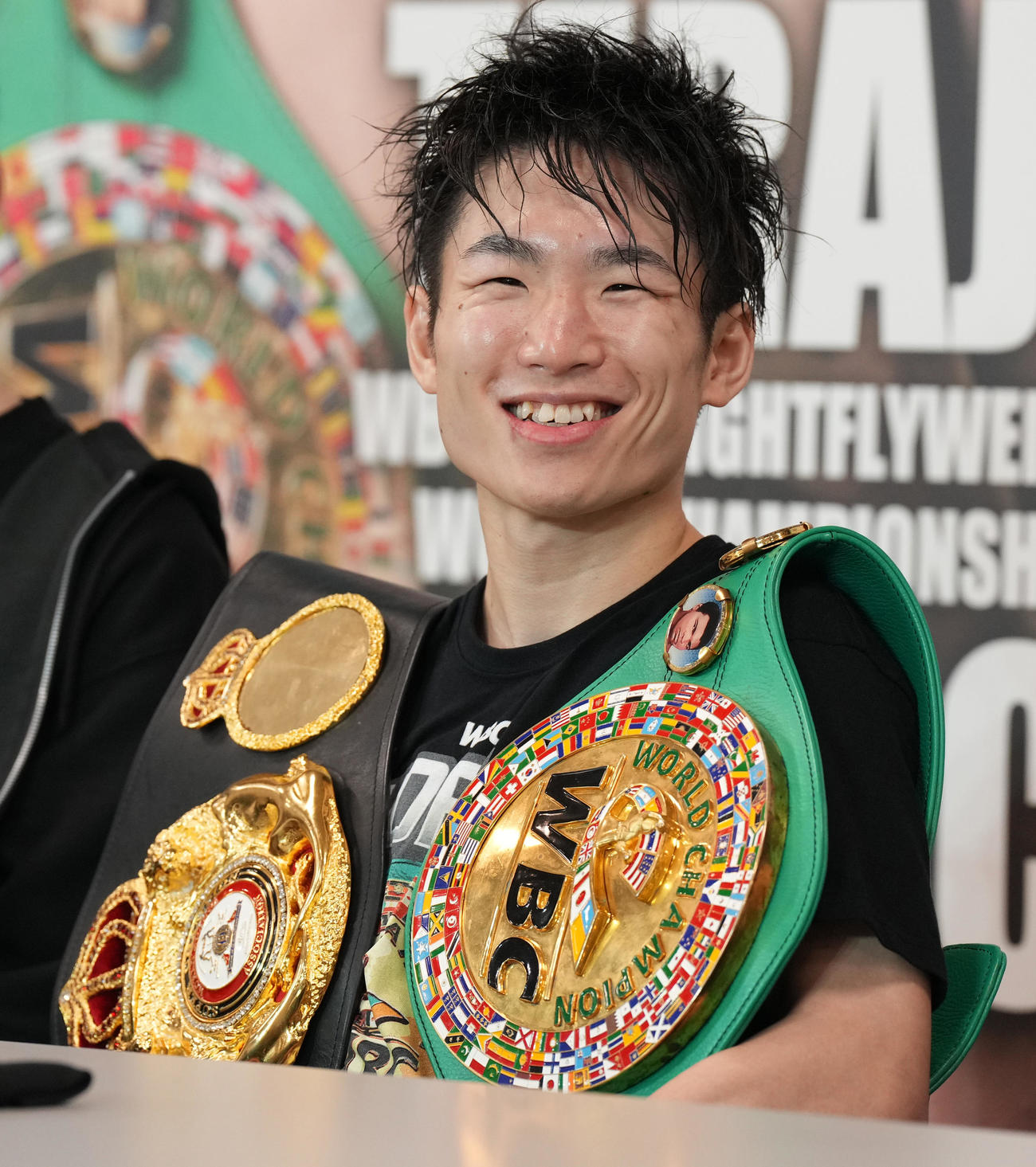 世界ライトフライ級2団体王座統一戦に勝利し、会見で2本のベルトを肩に笑顔を見せる寺地（2022年11月1日撮影）