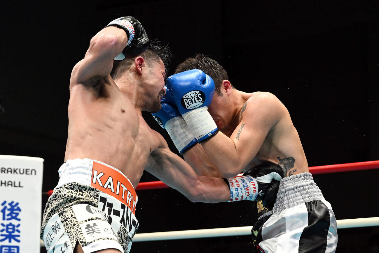 4回、比嘉（左）はソンセン・ポーヤムにパンチを見舞う（撮影・滝沢徹郎）