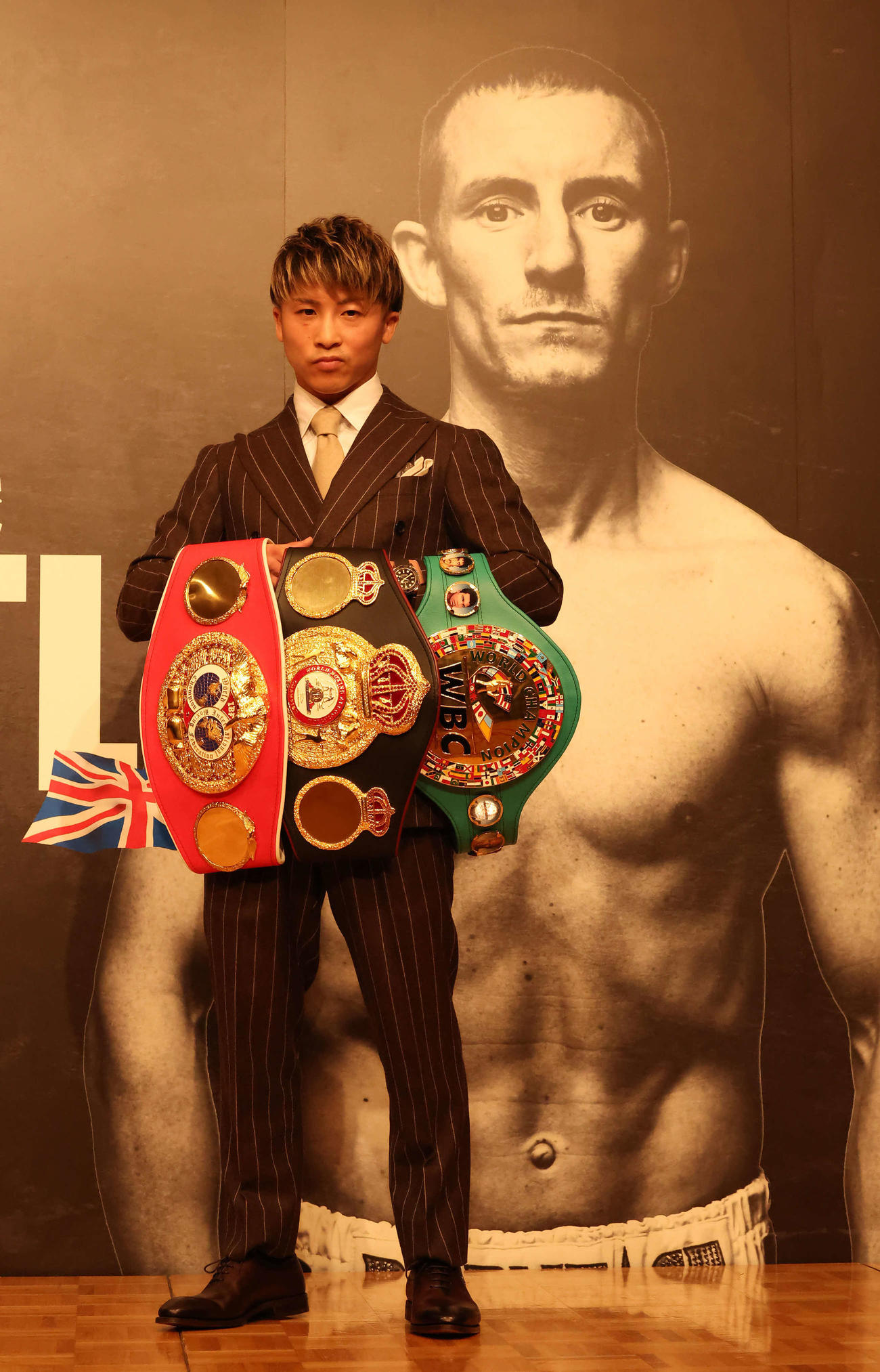 対戦相手ポール・バトラーの写真の前で写真に納まる井上（2022年10月13日撮影）