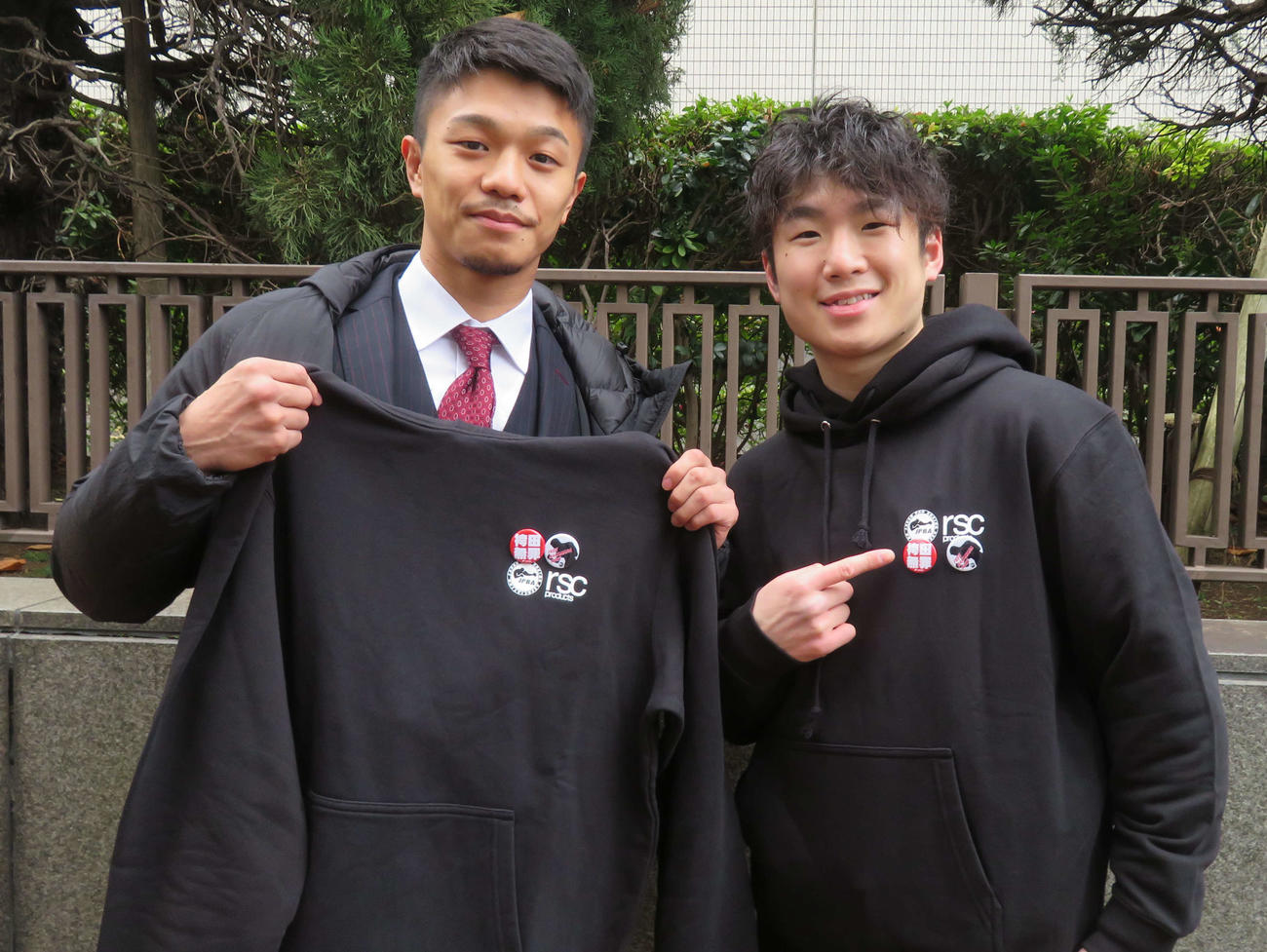 「袴田事件」の差し戻し審に臨む弁護団らに贈呈した支援の缶バッジとパーカを持つ中谷潤人（左）と寺地拳四朗