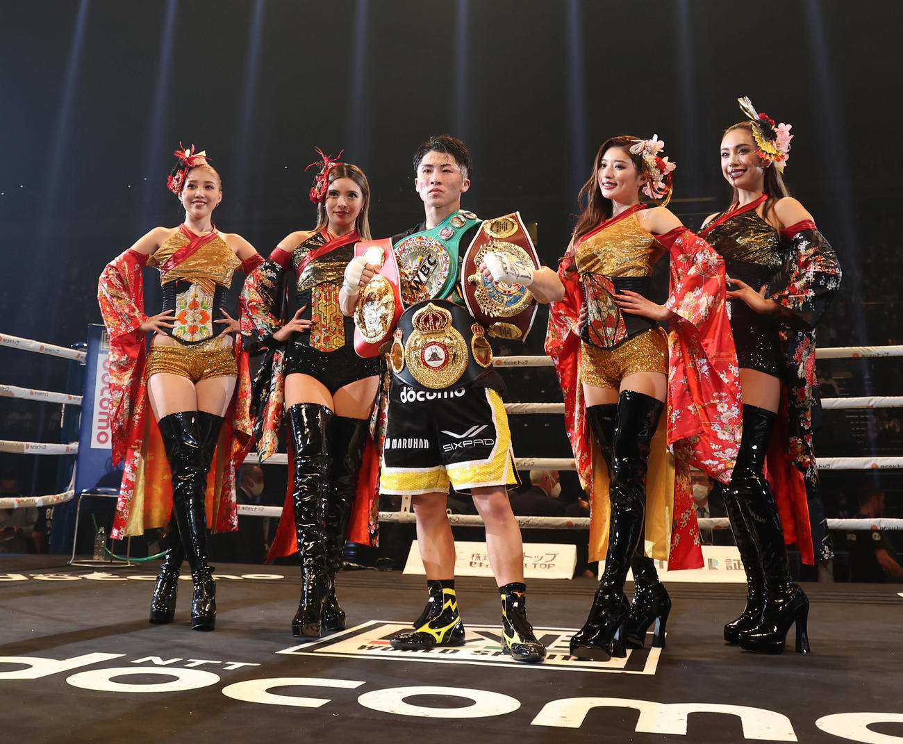 試合後、ラウンドガールとポーズを決める4団体の王座を統一した井上尚（中央）（代表撮影）