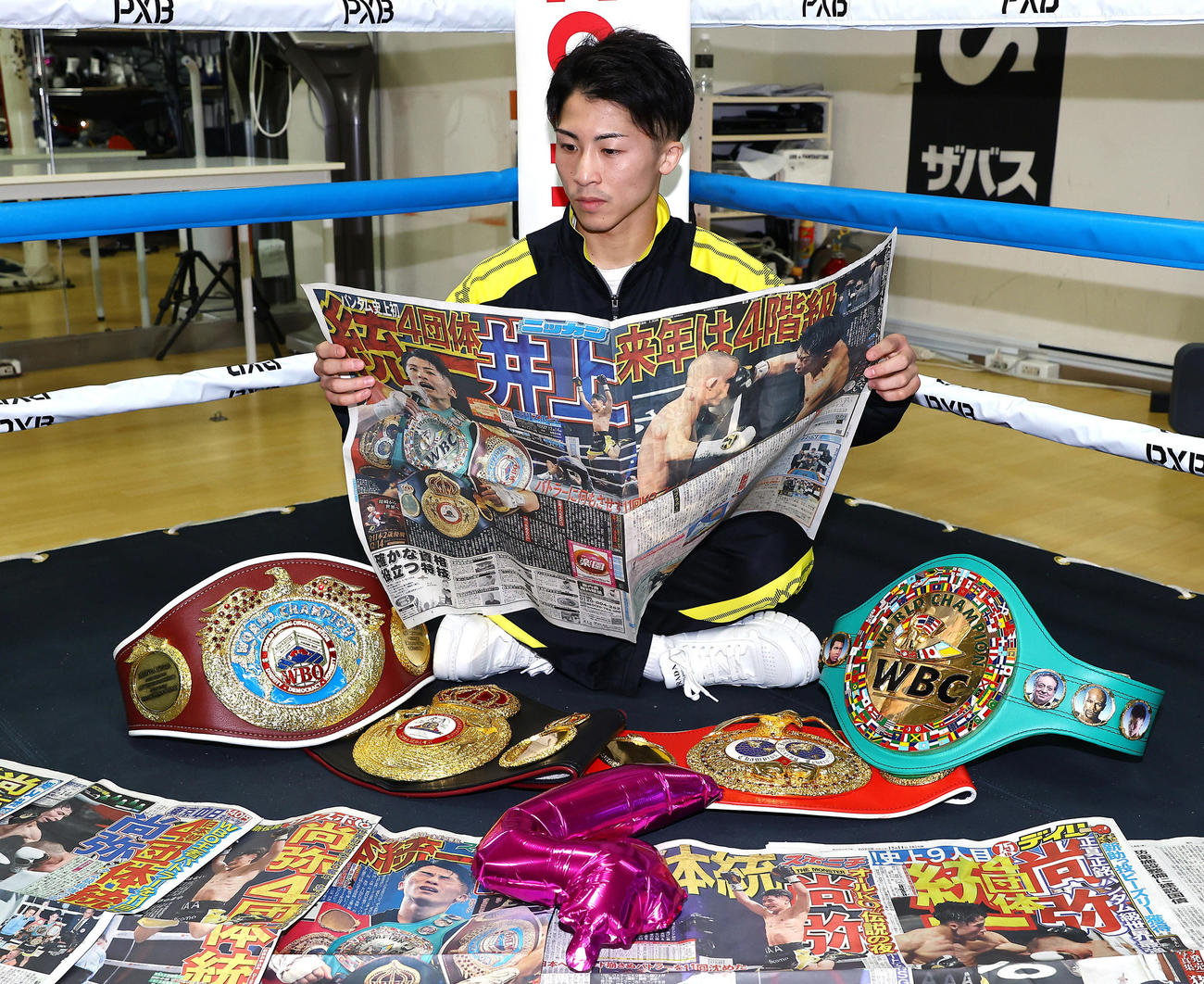 4団体統一から一夜明け一面で報じる日刊スポーツを読む井上尚（撮影・垰建太）