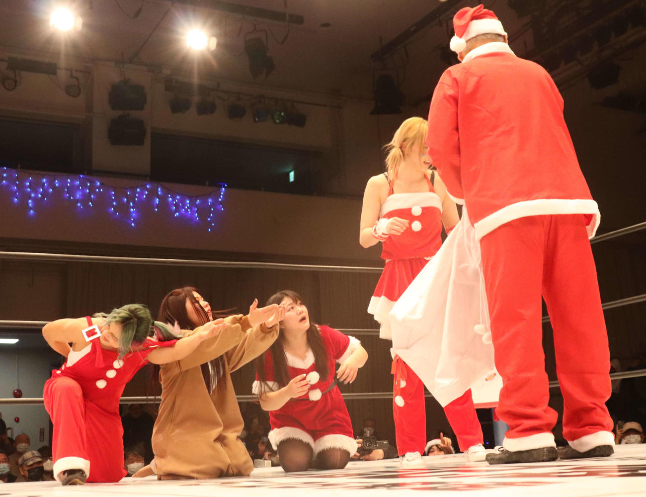 スターダム後楽園大会　勝利した岩谷麻優（右か2人目）はロッシー小川サンタからプレゼントを受け取る。左はうらやましがるSTARSのメンバー（撮影・渋谷征平）