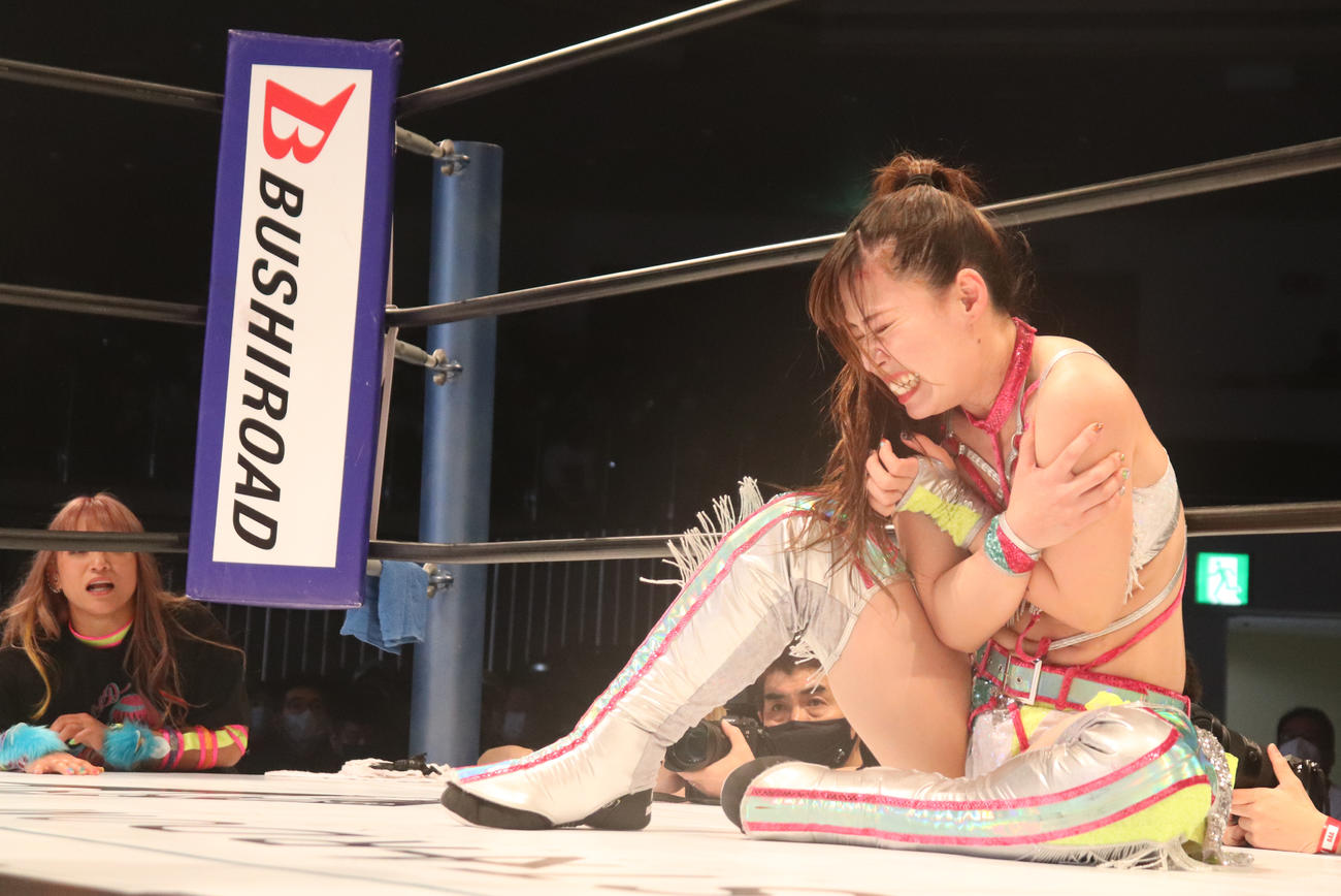 スターダム両国大会　AZMの攻撃を受け、苦ししい表情の清水ひかり（右）。左は心配そうに見つめるCOLOR'Sの仲間のSAKI（撮影・渋谷征平）