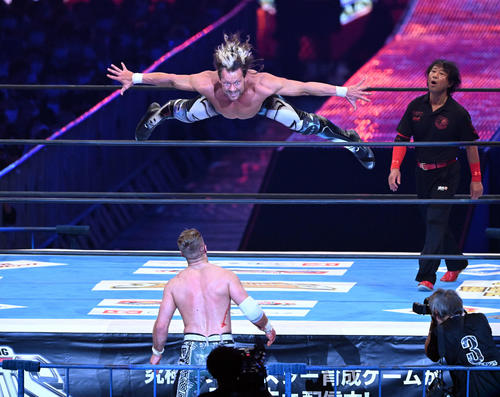 場外のウィル・オスプレイに向かって飛ぶケニー・オメガ（撮影・滝沢徹郎）