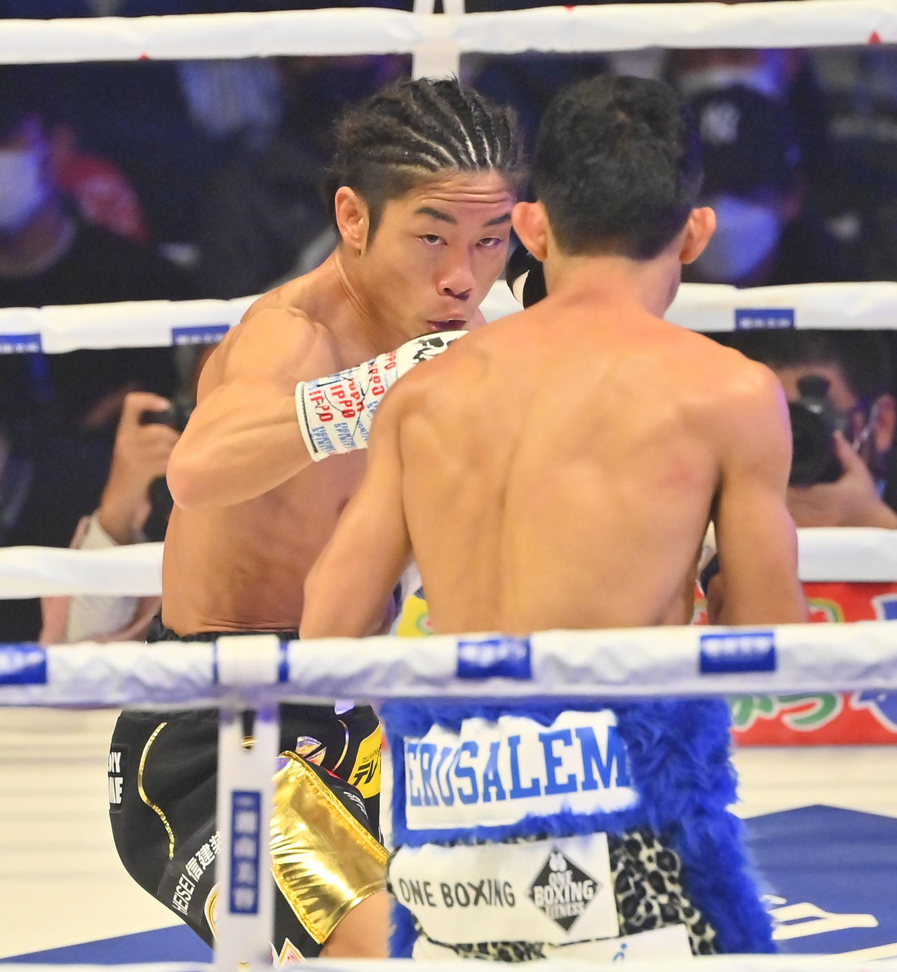2回、メルビン・ジェルサエム（右）にパンチを繰り出す谷口（撮影・和賀正仁）