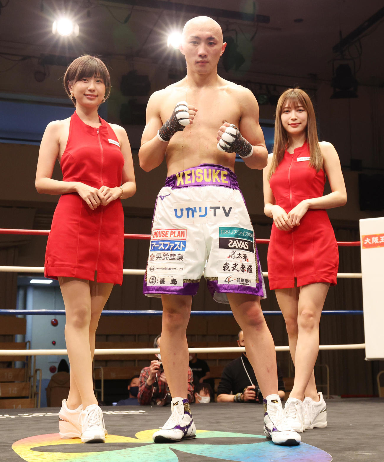 フェザー級8回戦で2回TKO勝ちしラウンドガールの天野麻菜（左）、雪平莉左（右）に祝福される松本（撮影・野上伸悟）