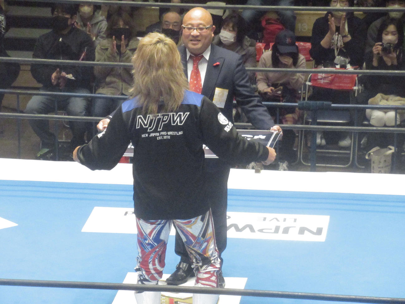 新日本プロレスの大会前に大谷晋二郎に寄付金贈呈式が開催。オッキー沖田に目録を手渡す棚橋（手前）（撮影・勝部晃多）