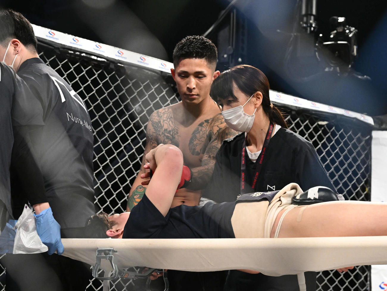 外枦保尋斗（後方）は担架で運ばれる有井皓太郎とタッチを交わす（撮影・滝沢徹郎）