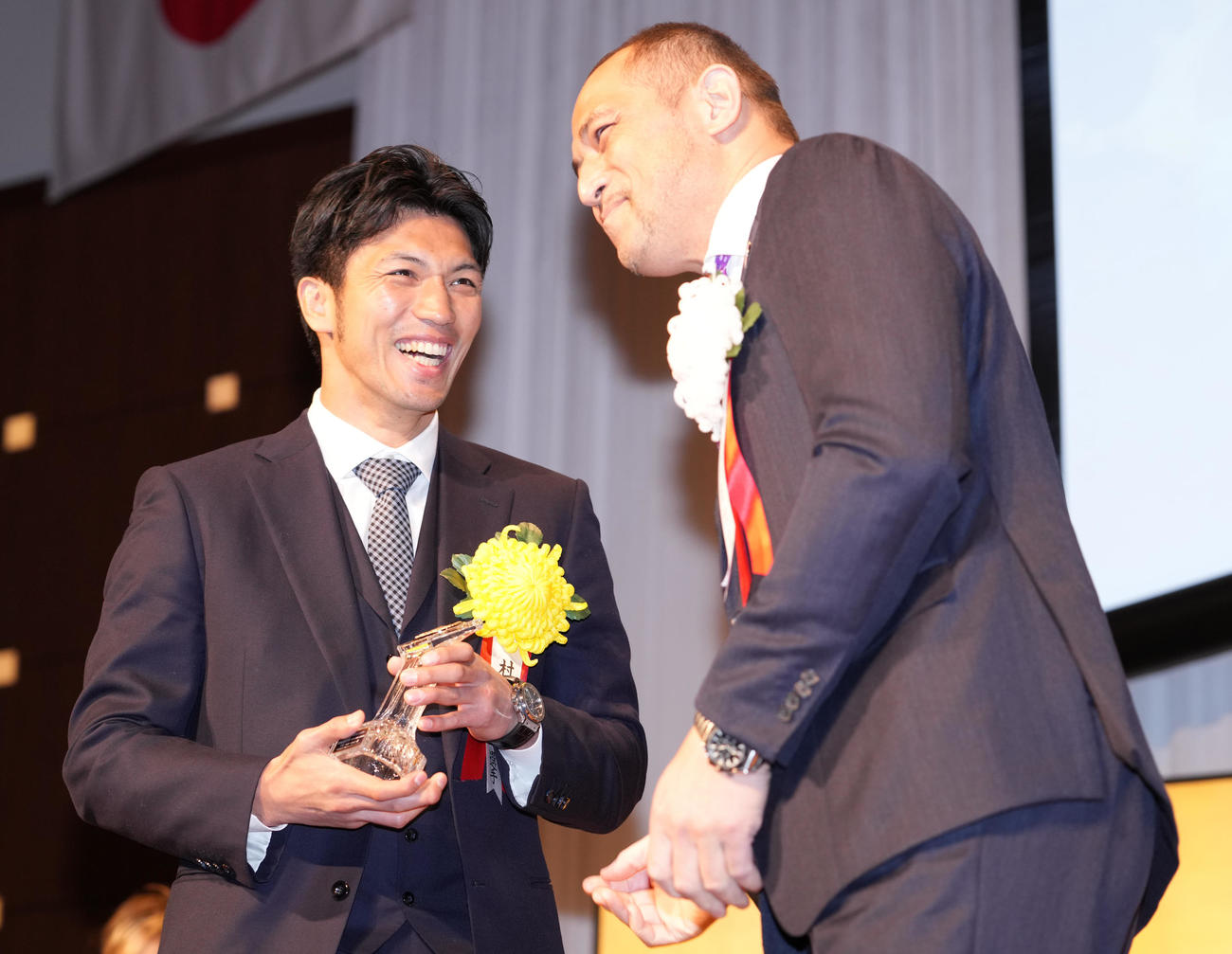 年間最高試合賞を受賞した村田（左）はスポーツ庁室伏広治長官からトロフィーを受け取り笑顔（撮影・鈴木みどり）
