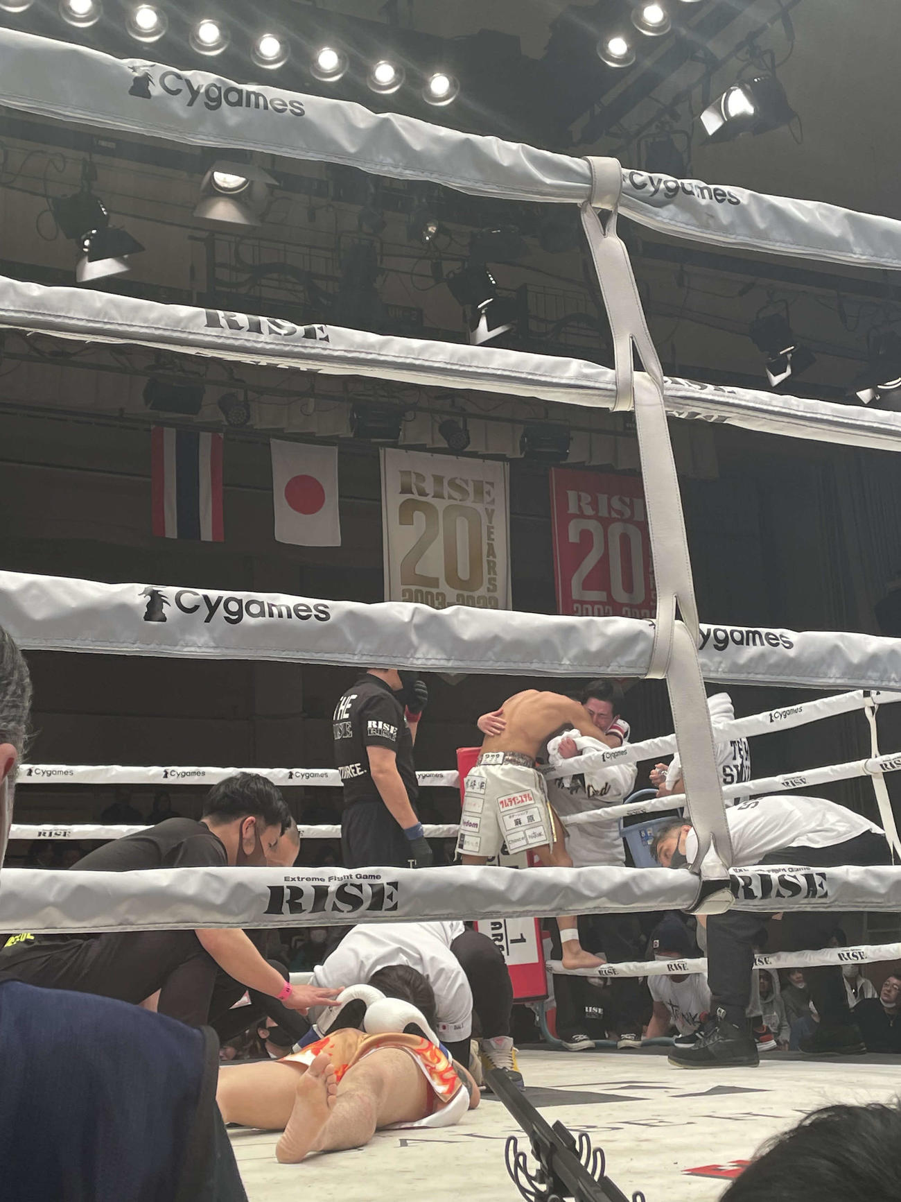 ライト級63キロ以下ワンマッチでKO勝利を飾り、トレーナーらと抱き合う麻原将平とリング上で横たわる対戦相手の瑠夏