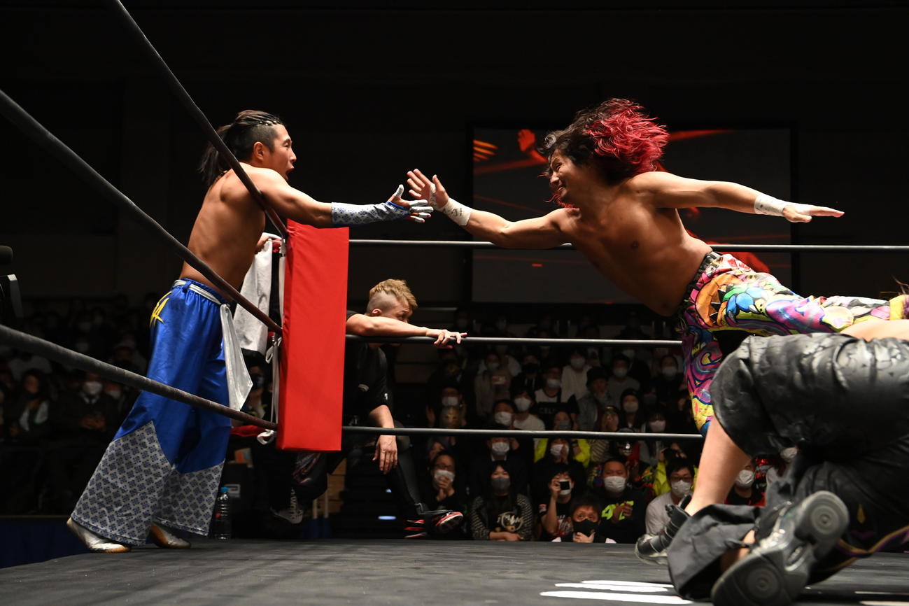 AMAKUSAにタッチする高橋ヒロム（右）（新日本プロレス提供）