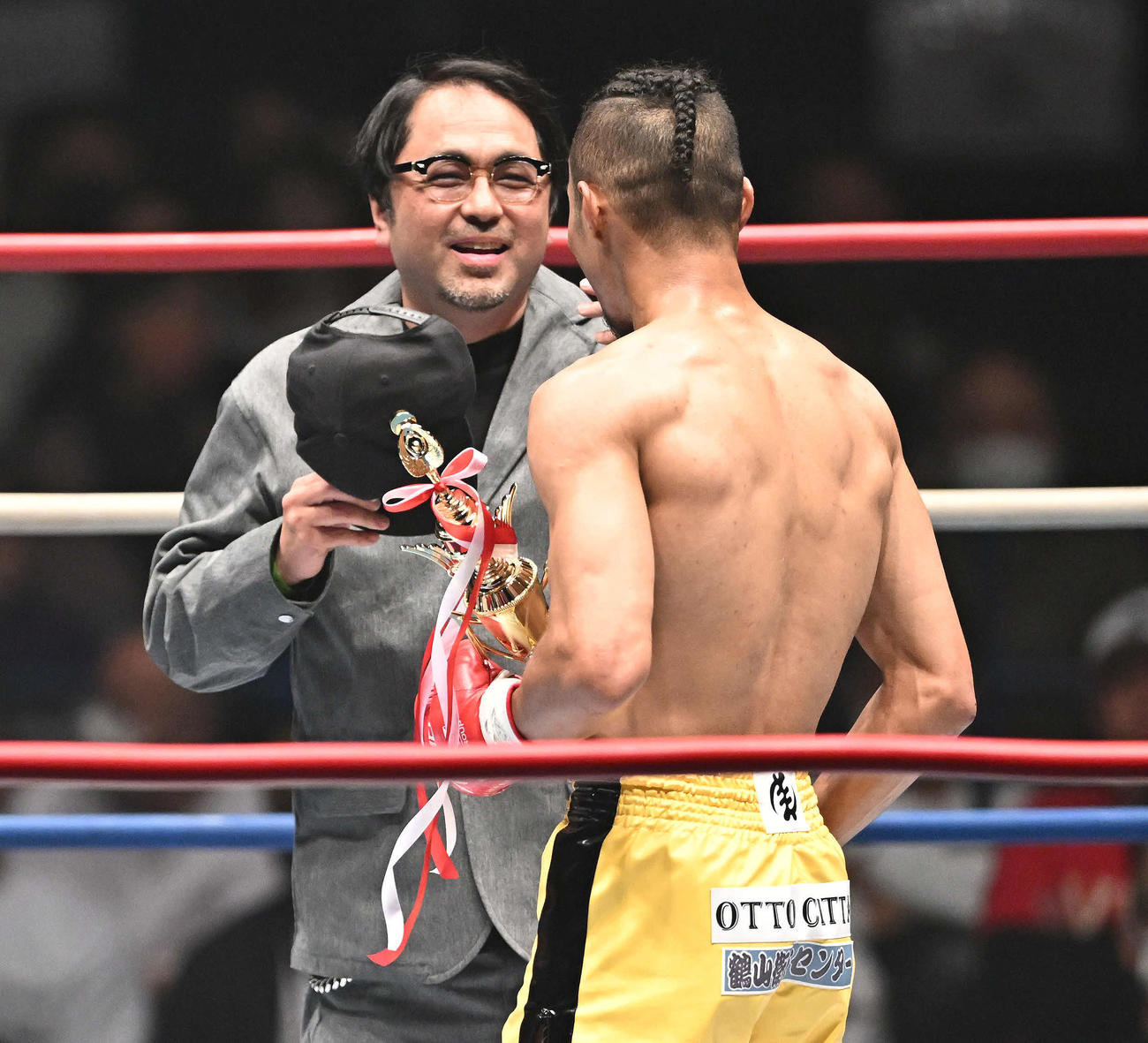 試合後、マッコイ斎藤氏（後方）は寧仁太・アリにトロフィーを渡す（撮影・滝沢徹郎）
