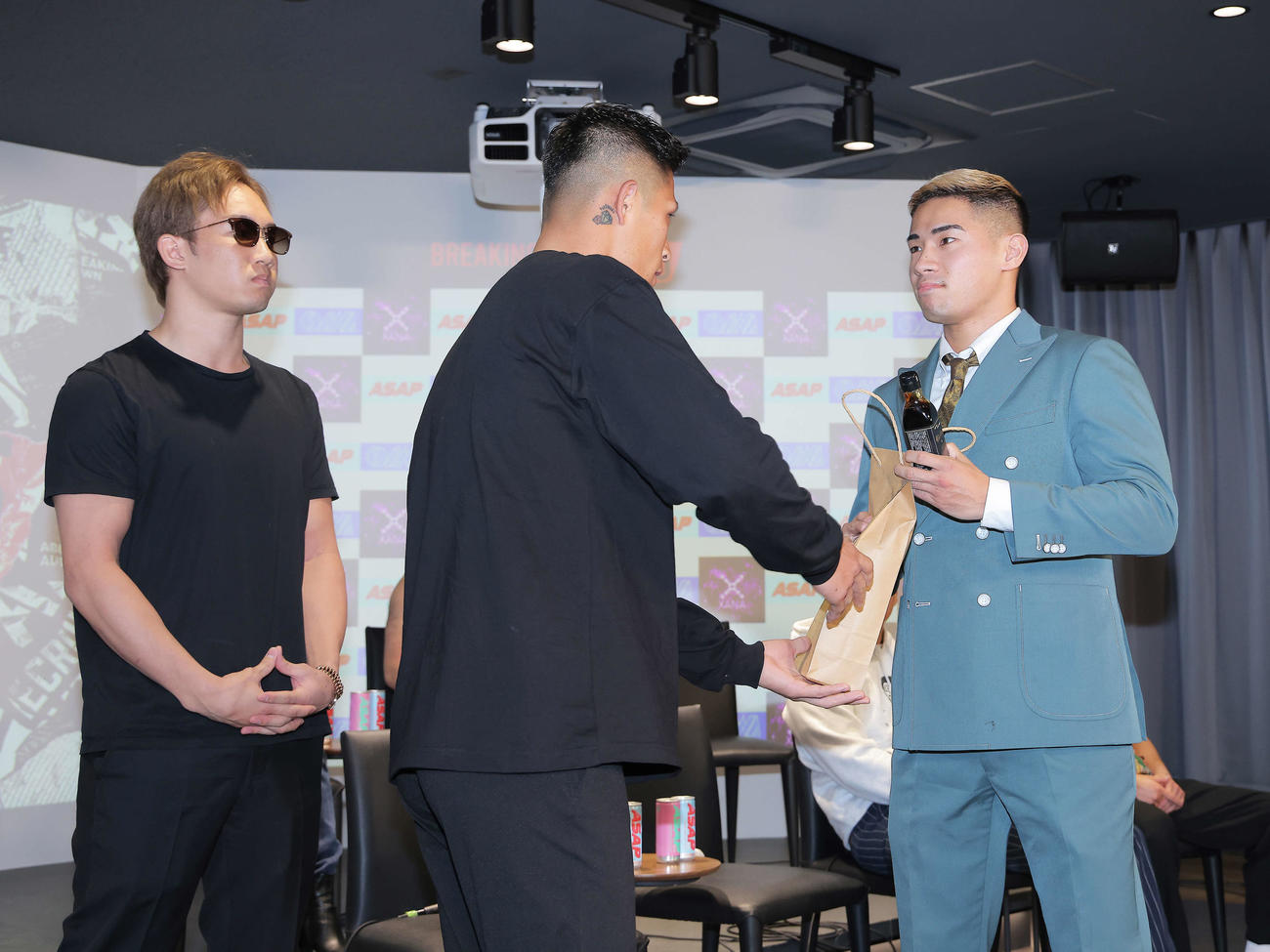 「BreakingDown7．5」記者会見で、外枦保尋斗（中央）は醤油ニキに醤油を渡す。左は朝倉未来（撮影・河田真司）