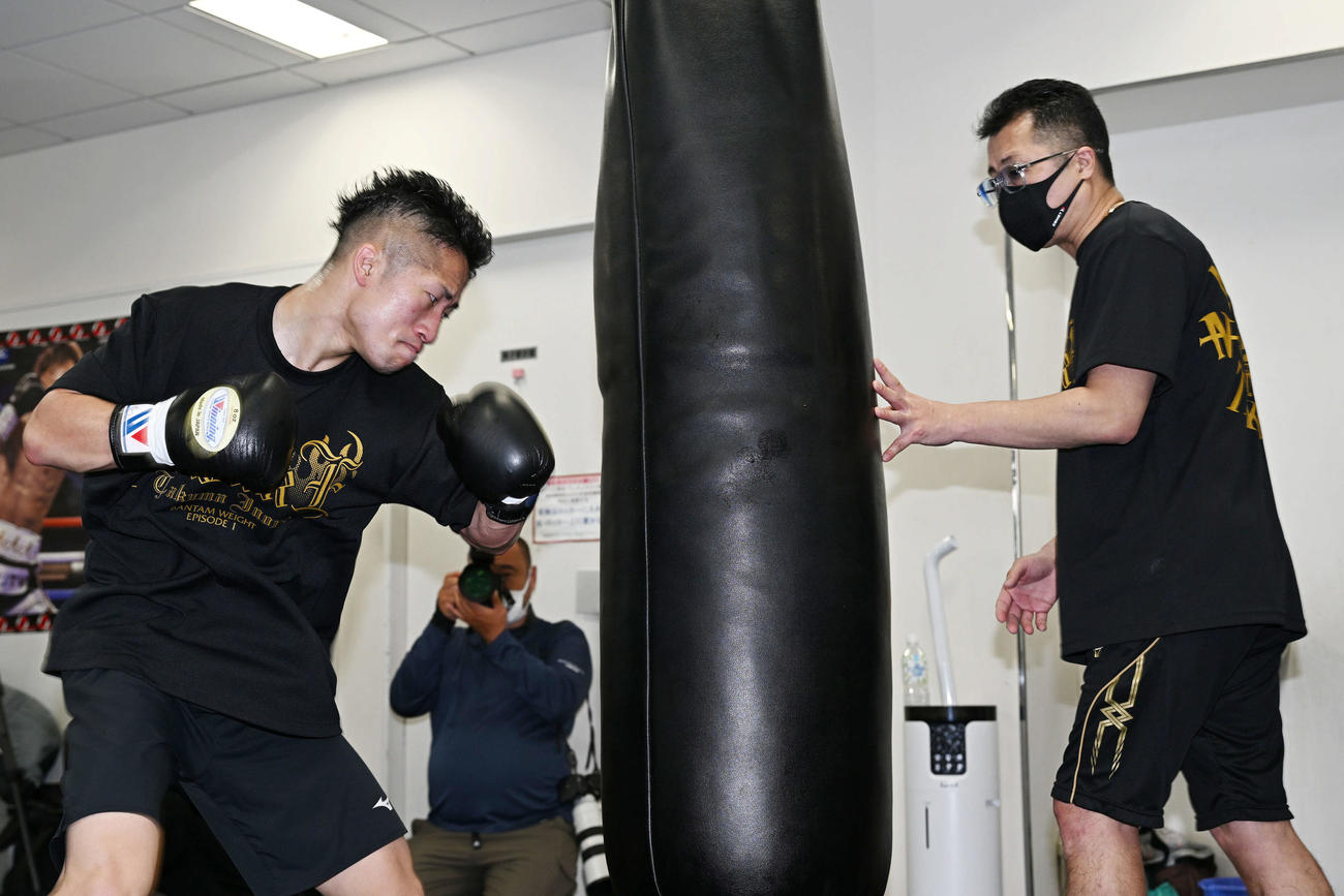 井上拓（左）は父の真吾トレーナーの支えるサンドバッグにパンチを打ち込む（撮影・滝沢徹郎）