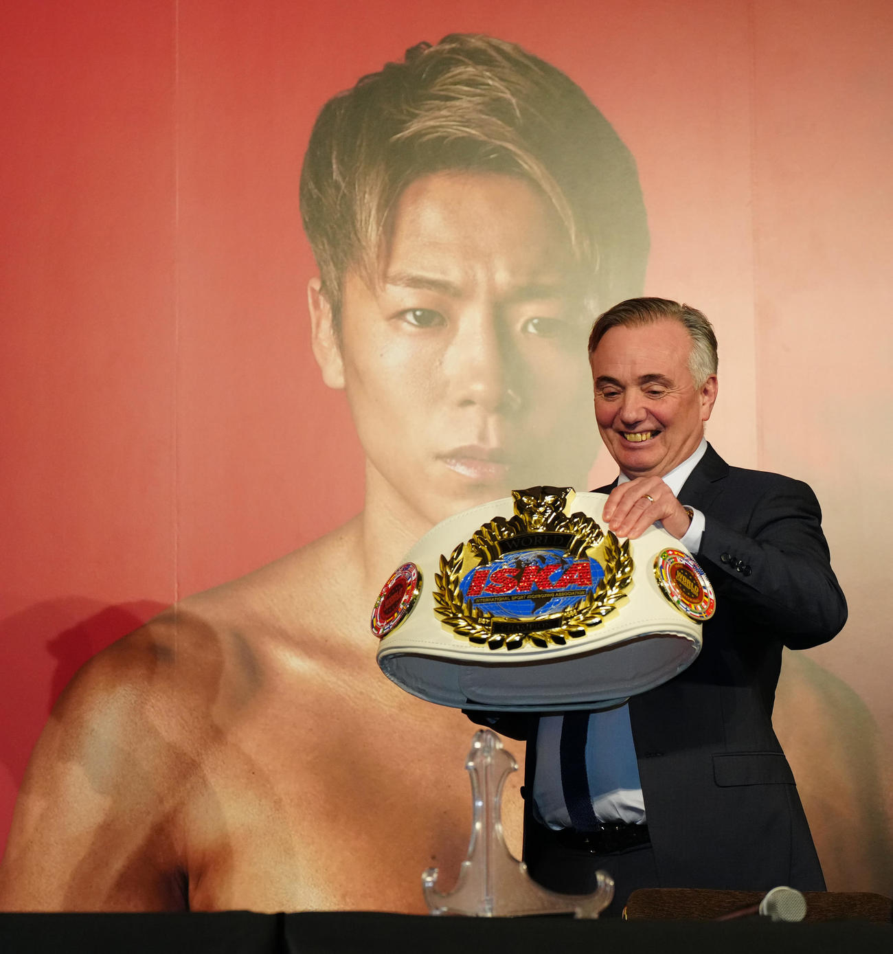 武尊の復帰戦決定会見でベルトを持って、登壇するISKAヨーロッパ代表ポール・ヘネシー氏（撮影・江口和貴）