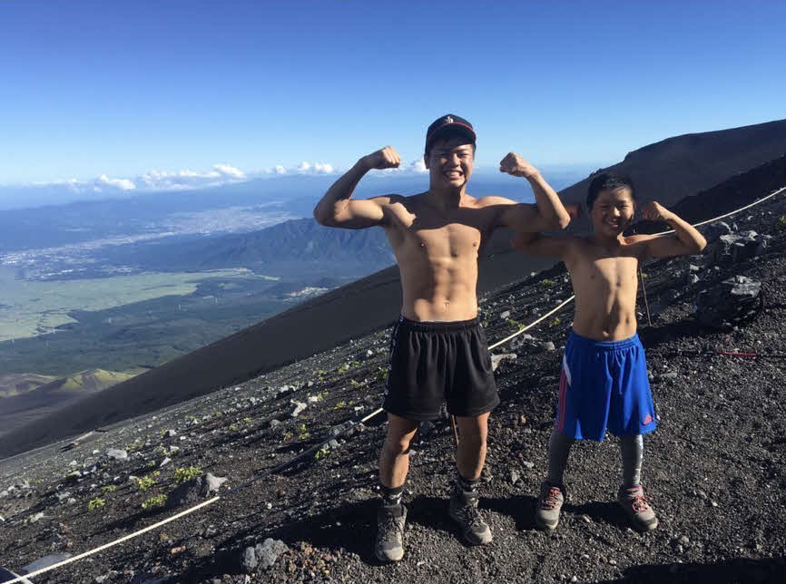 富士山をバックに筋肉をアピールする那須川天心（左）と実弟でプロ格闘家の龍心（那須川家提供）