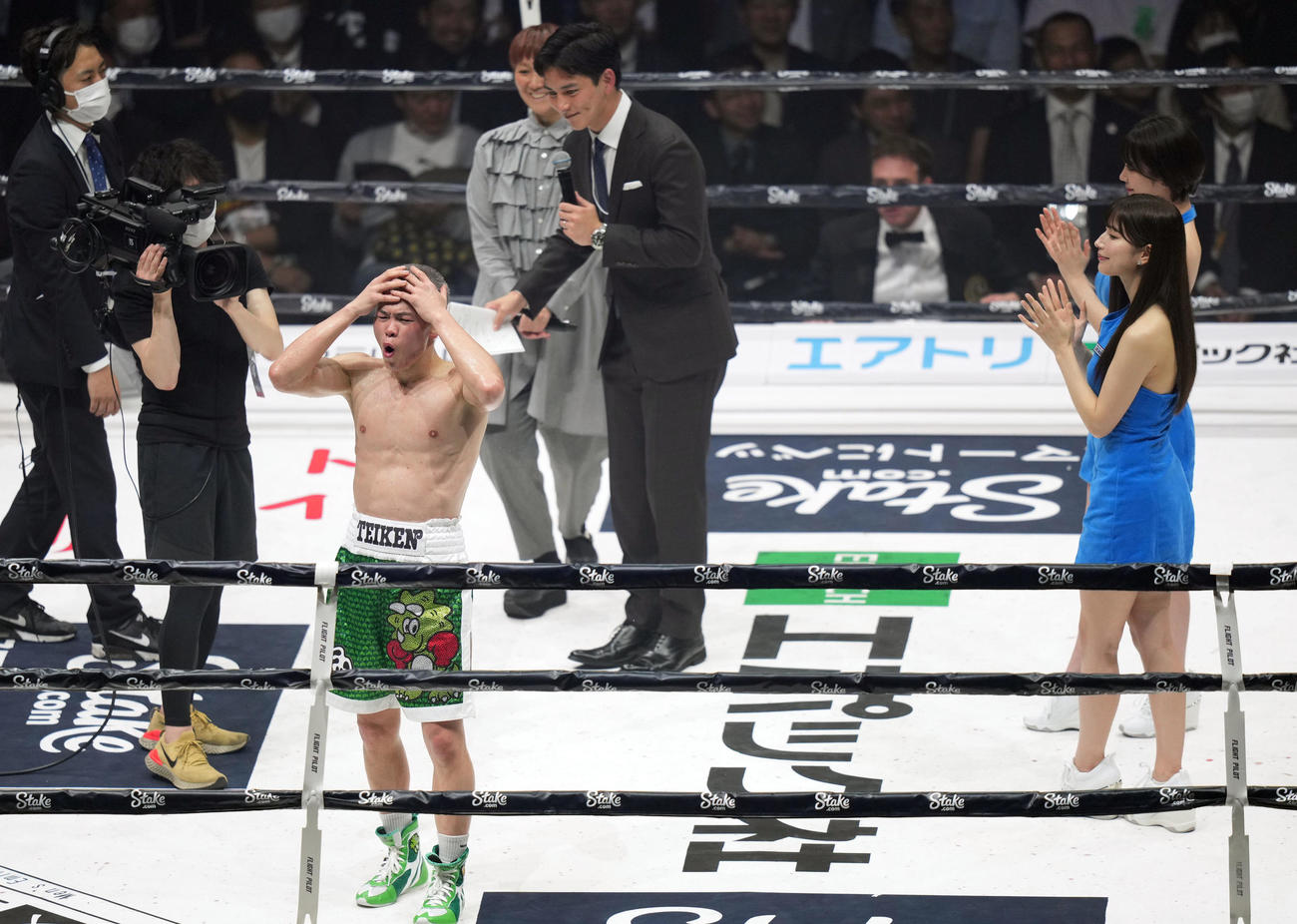 勝利インタビューを終え、頭を抱え、お茶目な表情を見せる那須川（撮影・狩俣裕三）
