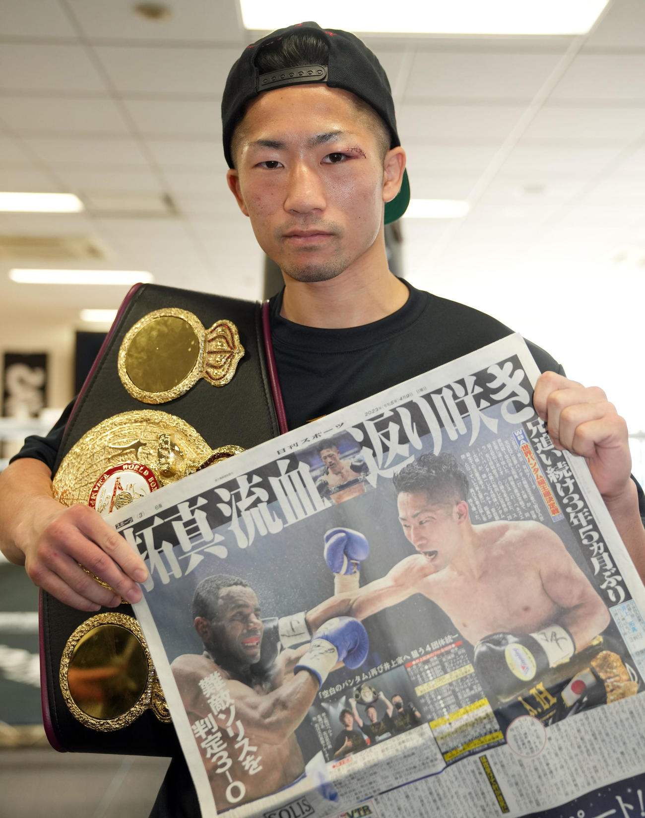 一夜明け会見で本紙を手に記念撮影する井上拓（撮影・狩俣裕三）