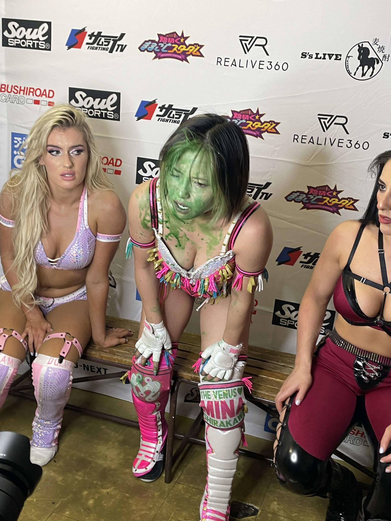 マライア・メイ（左）、ジーナに挟まれた白川未奈の顔にはは上谷沙弥から浴びせられた毒霧