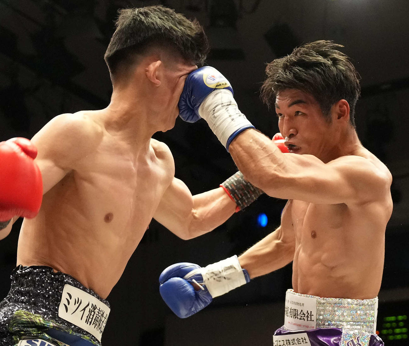 宇津木対仲里　1回、宇津木（左）の顔面にパンチを見舞う仲里（撮影・鈴木みどり）