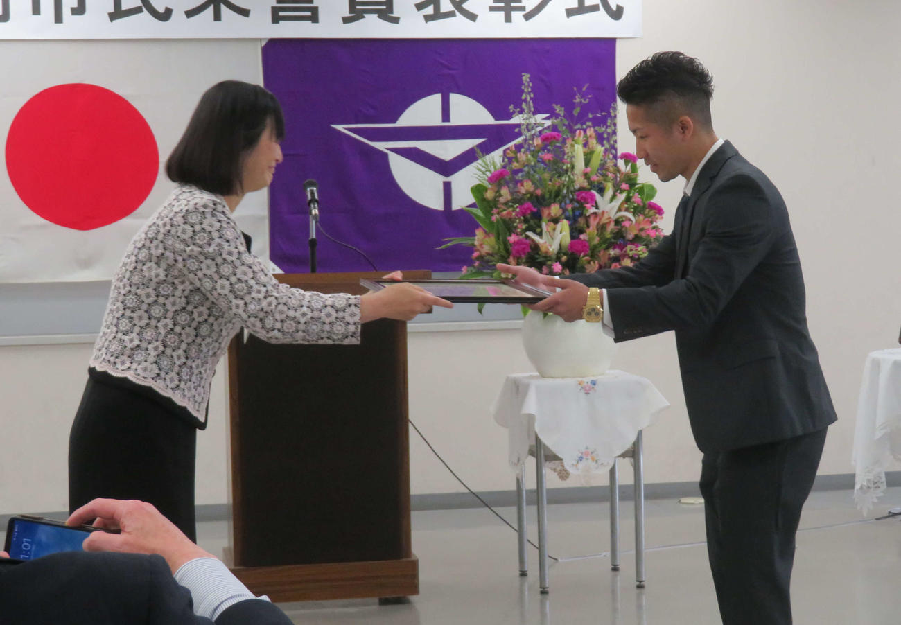 座間市の佐藤弥斗市長（左）から市民栄誉賞の賞状を受け取るWBA世界バンタム級王者井上拓真