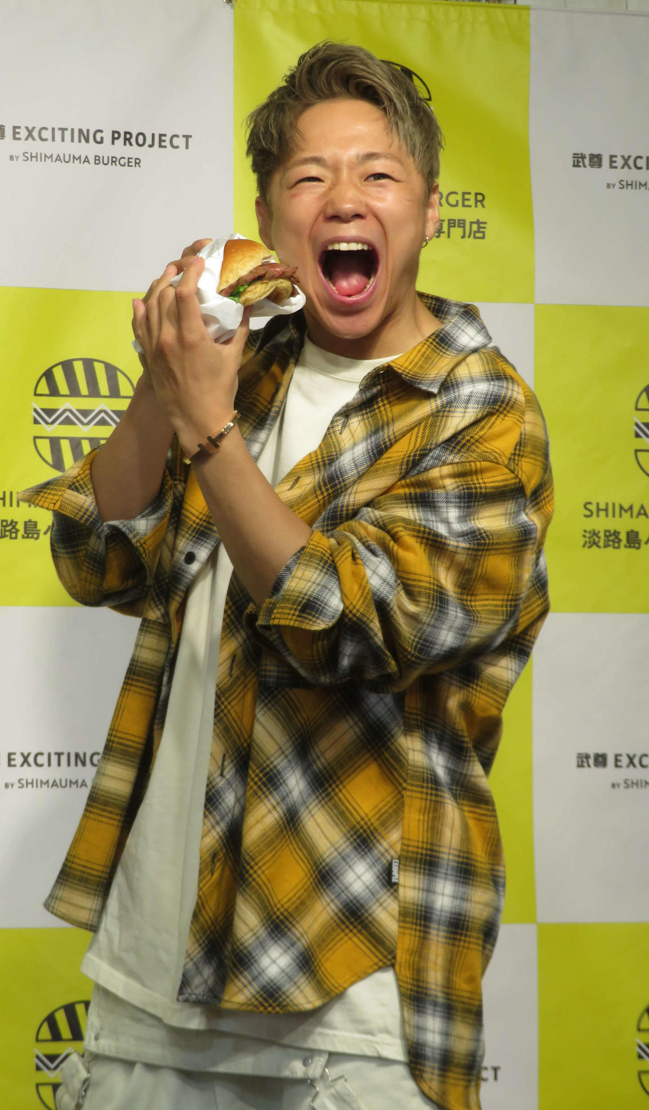 SHIMAUMA BURGERとコラボしたハンバーガーをPRする武尊