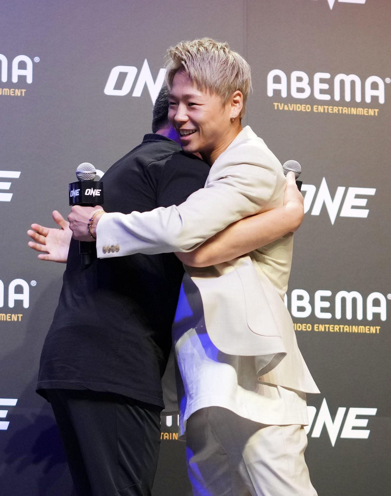 会見を終え抱き合う武尊（右）とチャトリ・シットヨートンCEO（撮影・横山健太）