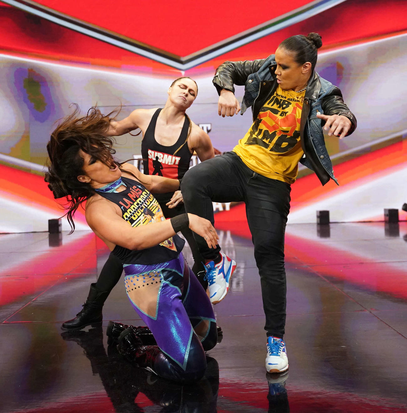WWE女子タッグ王者ラケル・ロドリゲス（左端）を襲撃したロンダ・ラウジー（中央）とシェイナ・ベイズラー（C）2023 WWE, Inc. All Rights Reserved.
