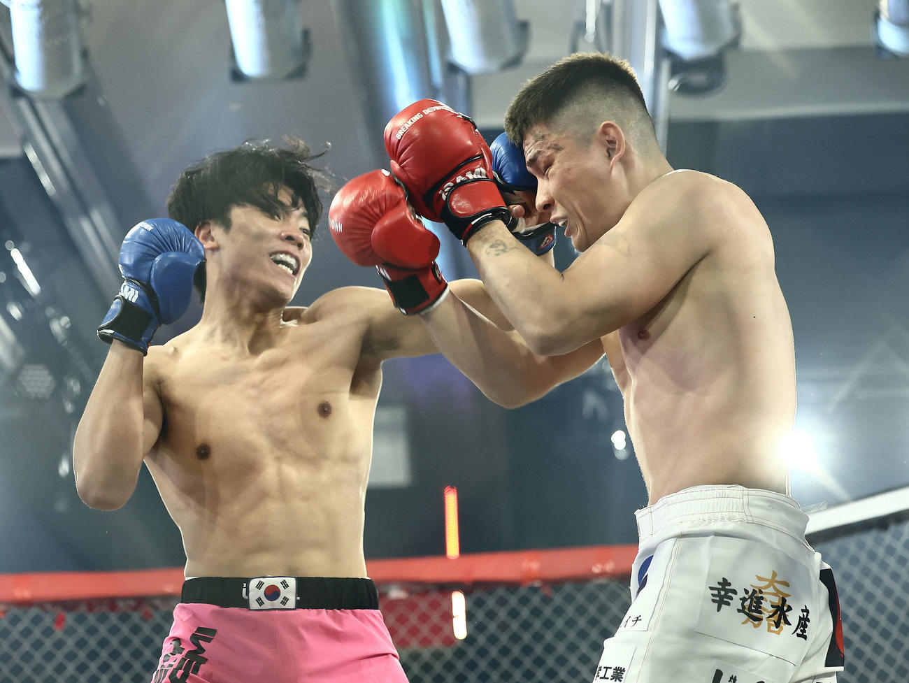 激しく打ち合うミスター・ホンデ（左）と信原空（撮影・河田真司）
