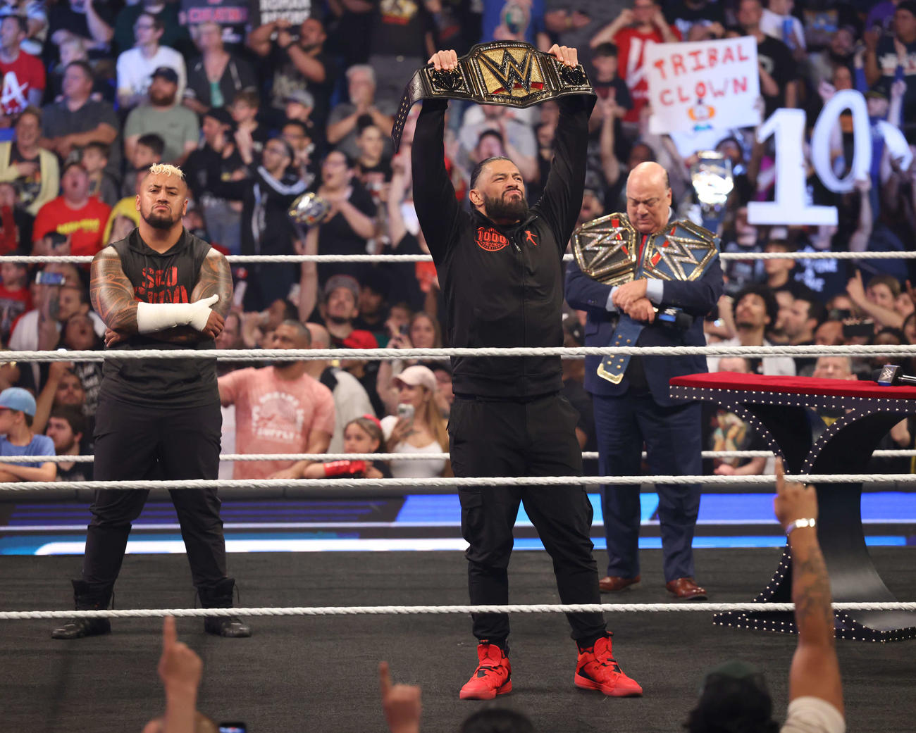 新たな統一王座ベルトを掲げるローマン・レインズ（中央）。左端はソロ・シコア、右端はポール・ヘイマン（C）2023 WWE, Inc. All Rights Reserved.