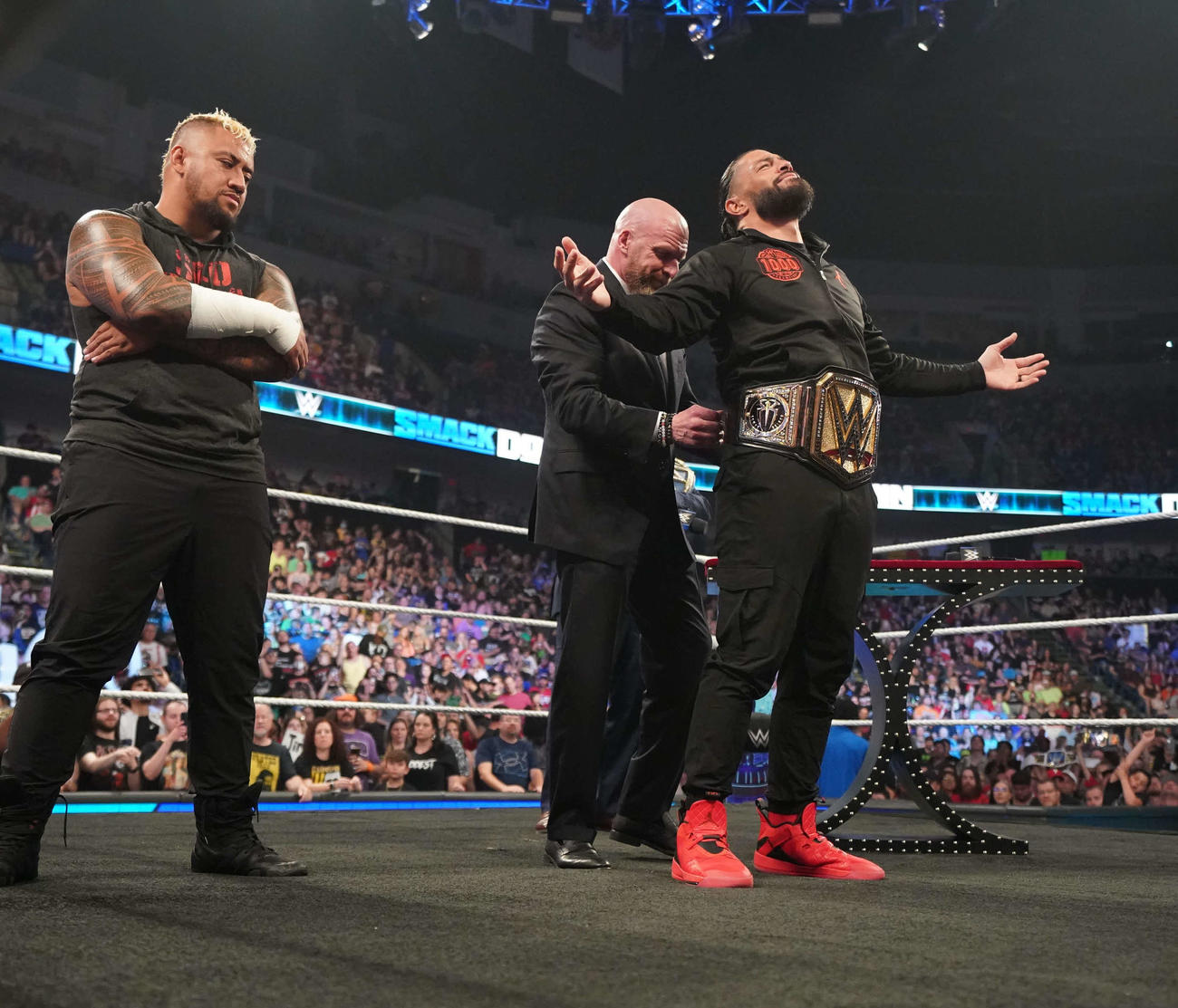 トリプルH（中央）に新たな統一王座ベルトを巻いてもらう統一王者ローマン・レインズ（右端）。左端はソロ・シコア（C）2023 WWE, Inc. All Rights Reserved.