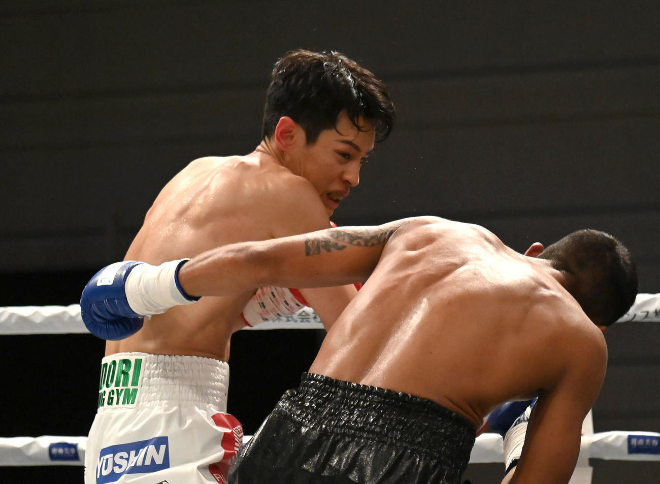 1回、リカルド・ヌニェス（右）にパンチを浴びせる力石政法（撮影・石井愛子）