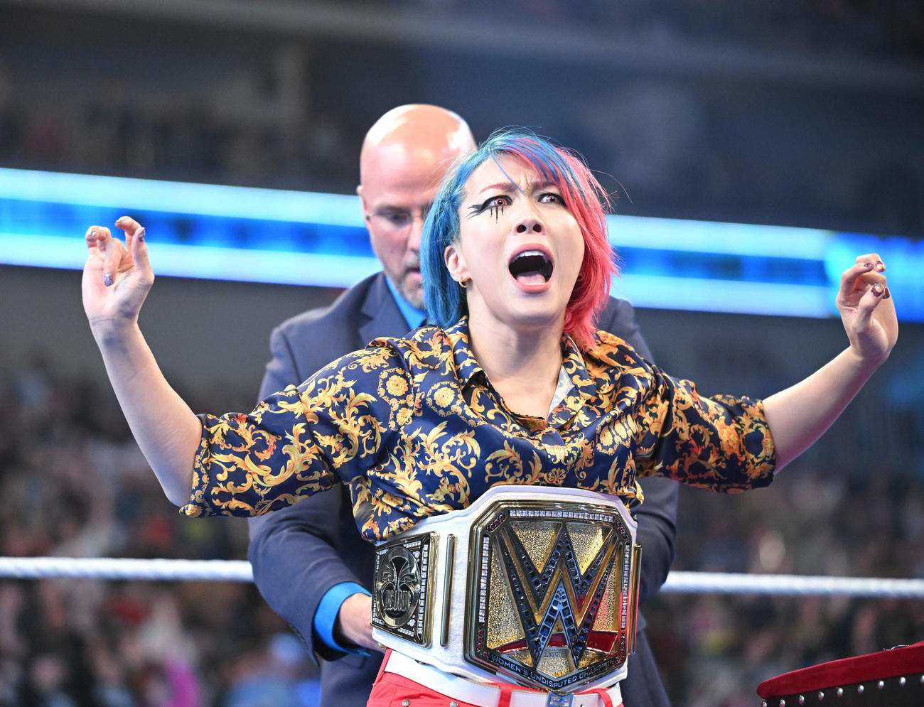 WWEオフィシャルのアダム・ピアースから新たなWWE女子王座ベルトを巻いてもらうロウ女子王者アスカ（C）2023 WWE, Inc. All Rights Reserved.