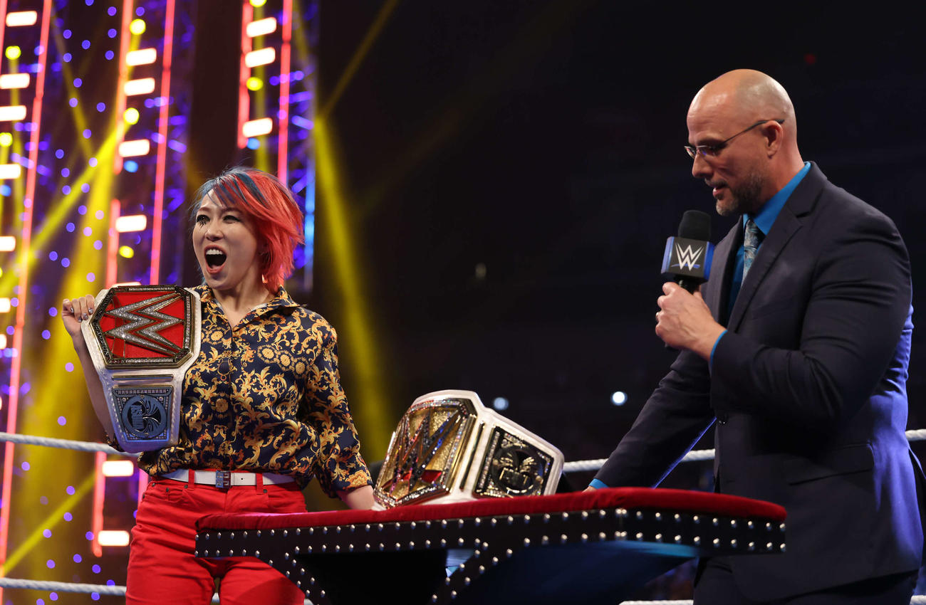 新たなWWE女子王座ベルトがお披露目されて喜ぶロウ女子王者アスカ。右はWWEオフィシャルのアダム・ピアース（C）2023 WWE, Inc. All Rights Reserved.