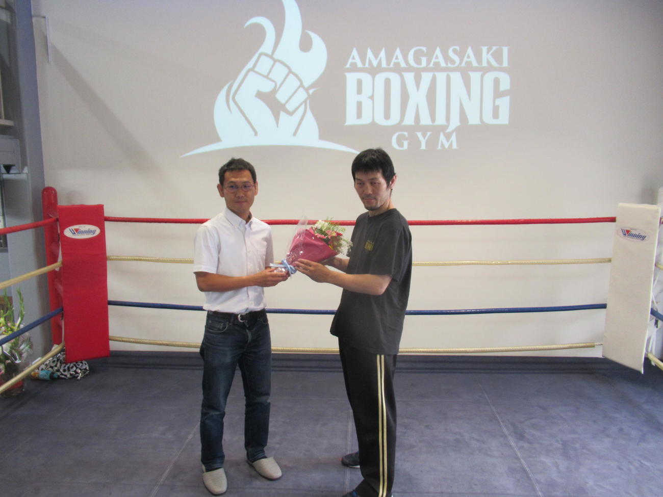 新装された尼崎ジムで宇久会長（右）に花束を贈る元世界王者の高山（2023・6・18　尼崎ジム　撮影・実藤健一）
