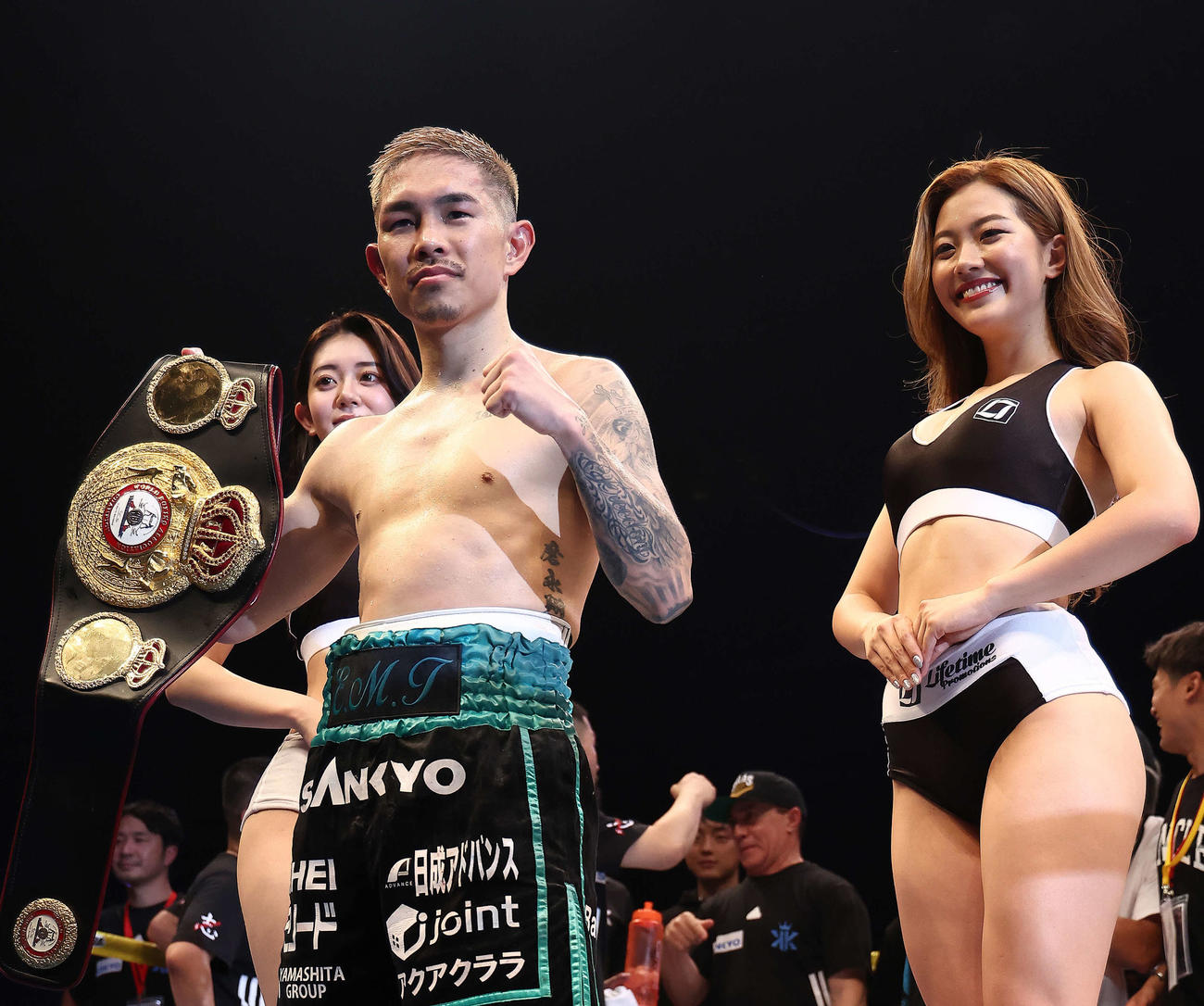 WBA世界スーパーフライ級のチャンピオンベルトを手に写真に納まる井岡。後方左は上原沙弓理、同右は石田梨緒（撮影・河田真司）