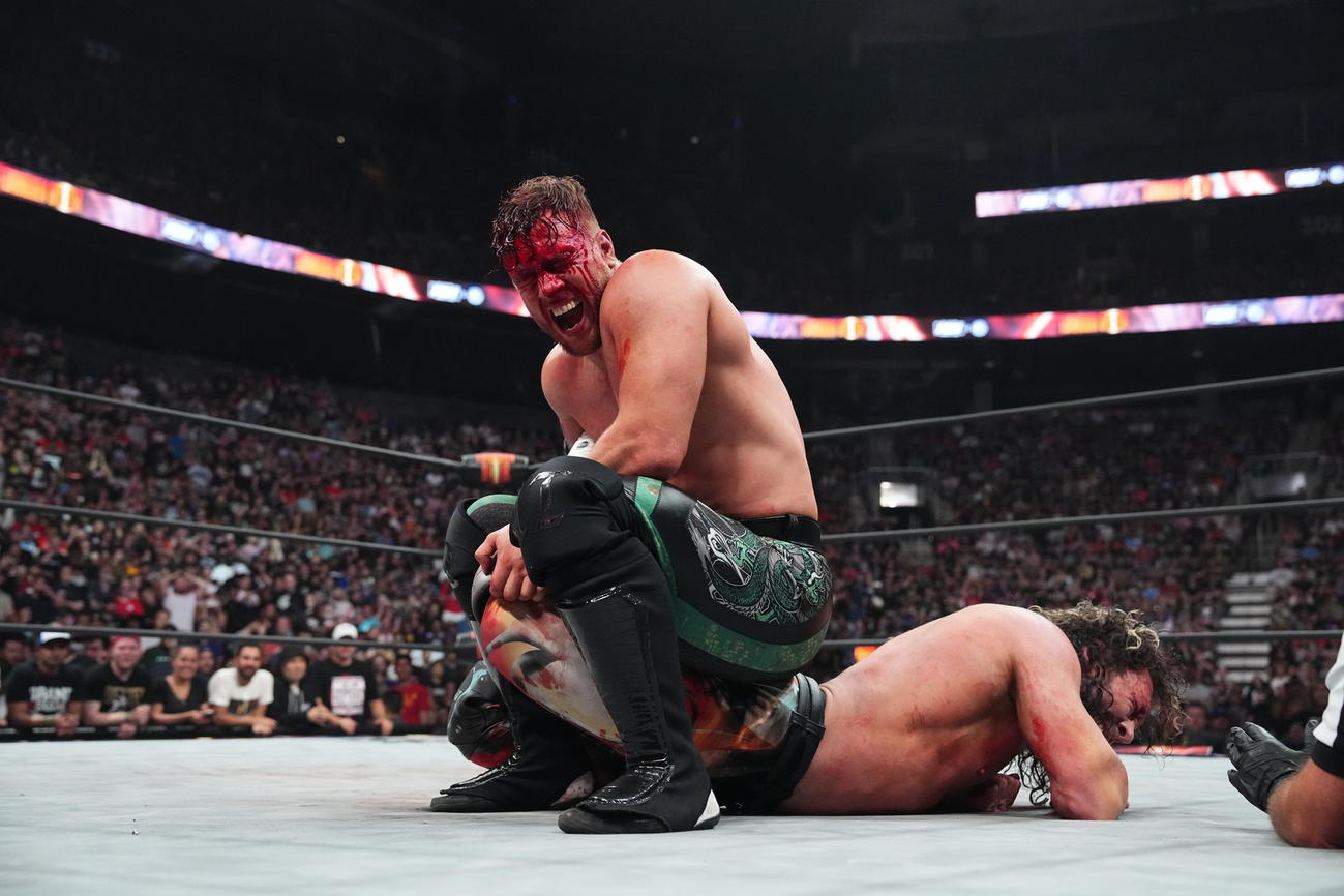流血しながら、ケニー・オメガの足を締め上げるウィル・オスプレイ【新日本プロレス提供】