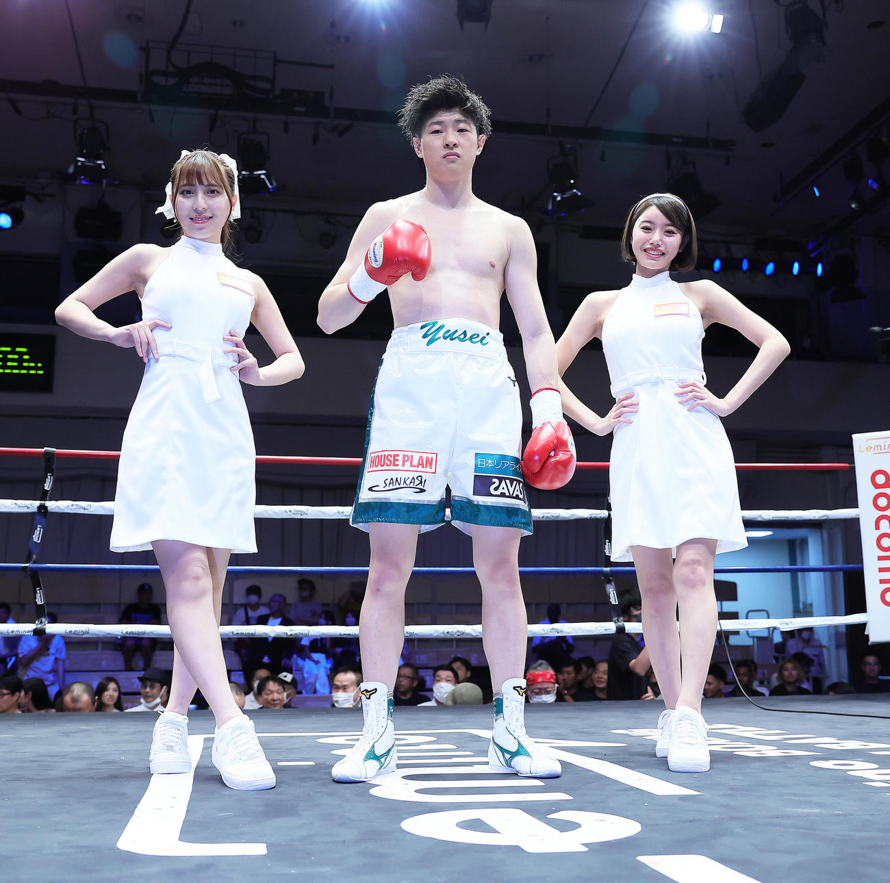 スーパーバンタム級6回戦　勝利し記念撮影に臨む山崎裕生。左はラウンドガールの竹内星菜、右は長瀬礼華（撮影・足立雅史）
※山崎の崎は崎の大が立の下の横棒なし