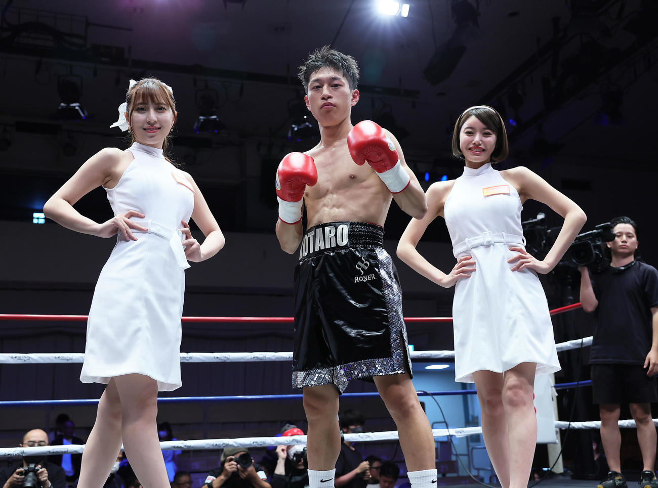 フライ級4回戦　勝利し記念撮影に臨む水口。左はラウンドガールの竹内星菜、右は長瀬礼華（撮影・足立雅史）