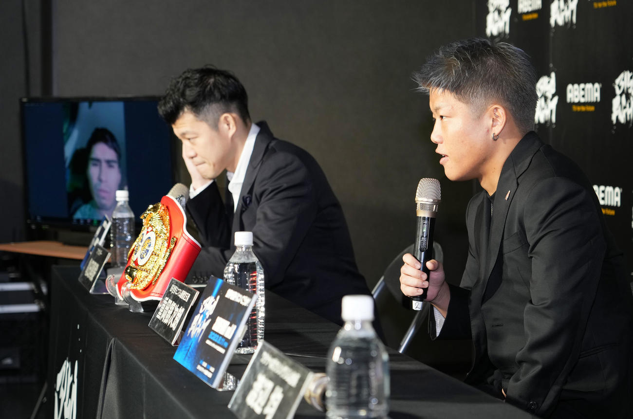 IBF世界ミニマム級王座統一戦の会見でビデオ出演する王者バラダレス（左）を横目に抱負を話す暫定王者重岡。中央は亀田興氏（撮影・菅敏）