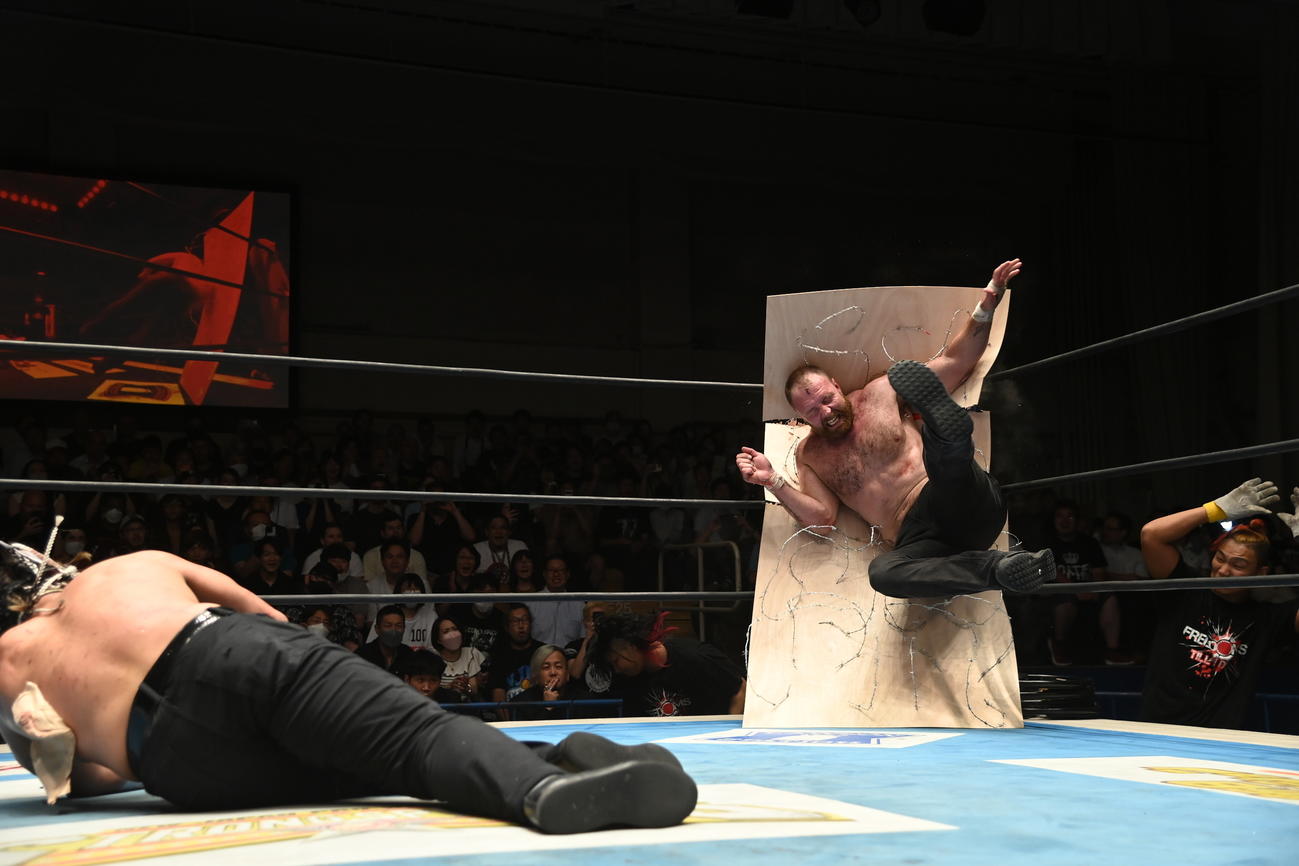エル・デスペラードに有刺鉄線ボードへたたきつけられるジョン・モクスリー（新日本プロレス提供）