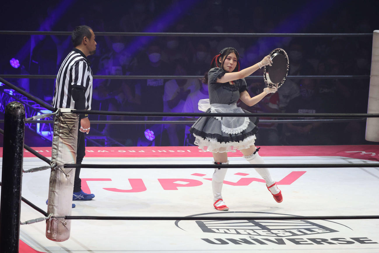 東京女子大田区大会　トレイを持ち、リズムをとるメイ・サン＝ミッシェル（右）と、つられてノってしまうレフェリー（撮影・渋谷征平）