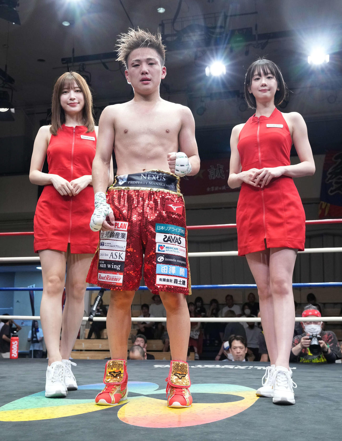 判定勝ちを収めファイティングポーズを披露する森（中央）。左はラウンドガールの雪平莉左、右は新唯（撮影・小沢裕）