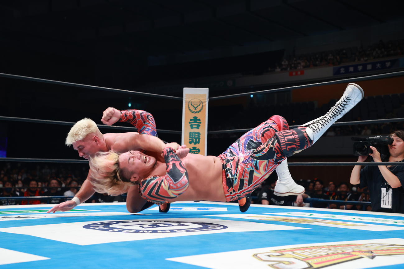 ザック・セイバーJr．（後方）からの攻撃を受ける棚橋弘至（新日本プロレス提供）