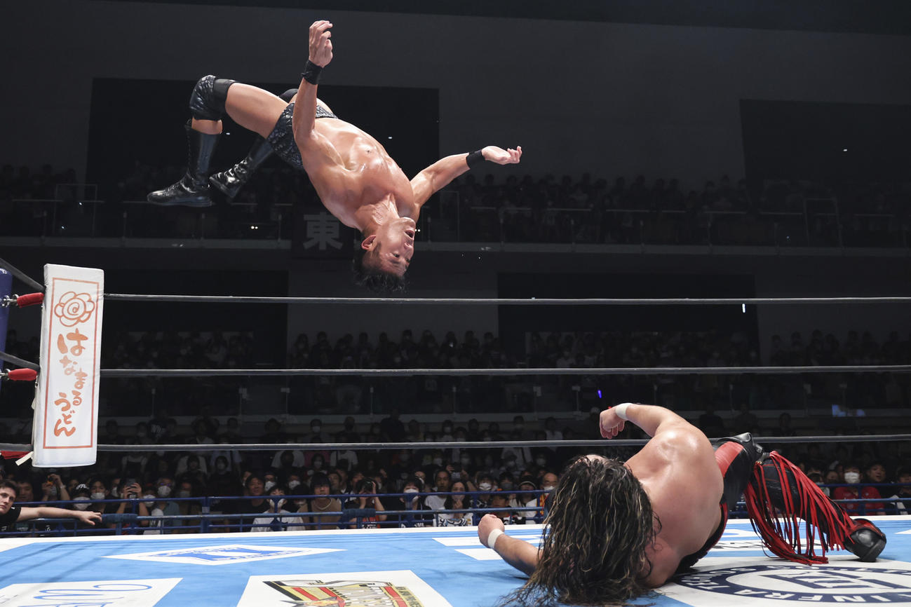 リングで横たわる辻陽太へ、コーナートップからしかけるSANADA（新日本プロレス提供）