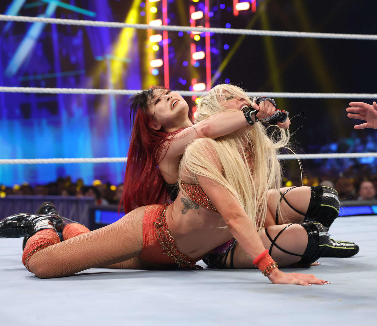 シャーロット・フレアー（手前）をクロスフェイスで追い詰めるイヨ・スカイ（C）2023 WWE, Inc. All Rights Reserved.