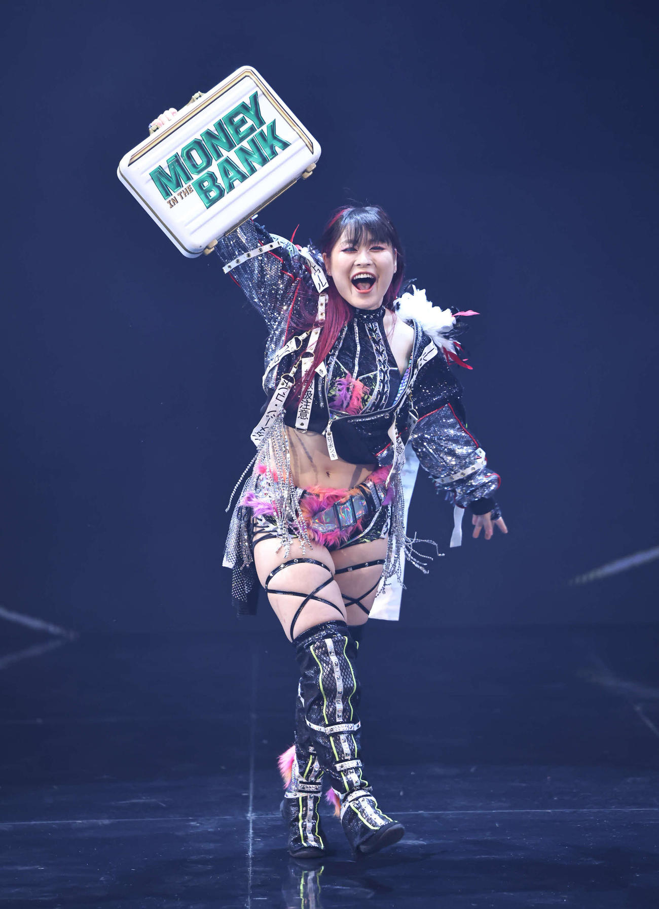 王座挑戦権利証入りブリーフケースを掲げて入場するイヨ・スカイ（C）2023 WWE, Inc. All Rights Reserved.